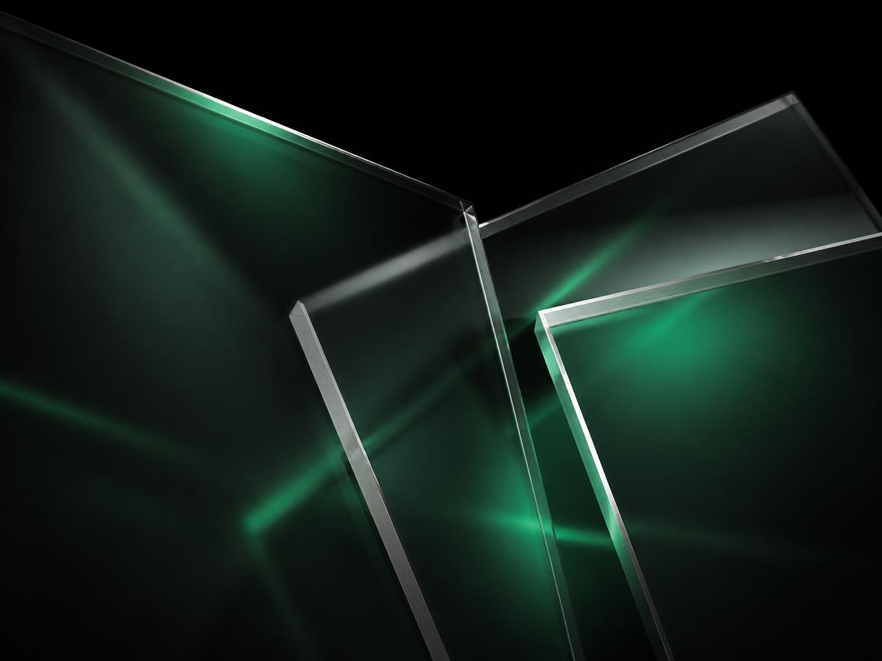 Abstract frosted glass panels with metallic edges and emerald light, representing multi-channel media allocation